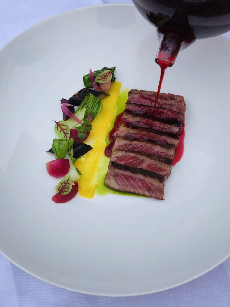 Wagyu japonais grillé en fines tranches, légumes d’hiver, condiment à l’orange et bouillon de betterave perlé à l’huile de céleri.